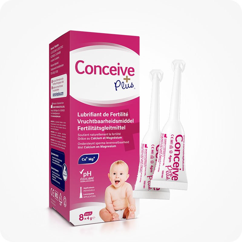 Conceive Plus Fertility Lubricant, Pre-Filled Applicators (FR) 8x4g pack shown with two single-use applicators. The box features multilingual labeling (French, Dutch, German), highlighting calcium and magnesium ions benefits, pH balance, and support for sperm viability. Baby graphic included on pink and white packaging.