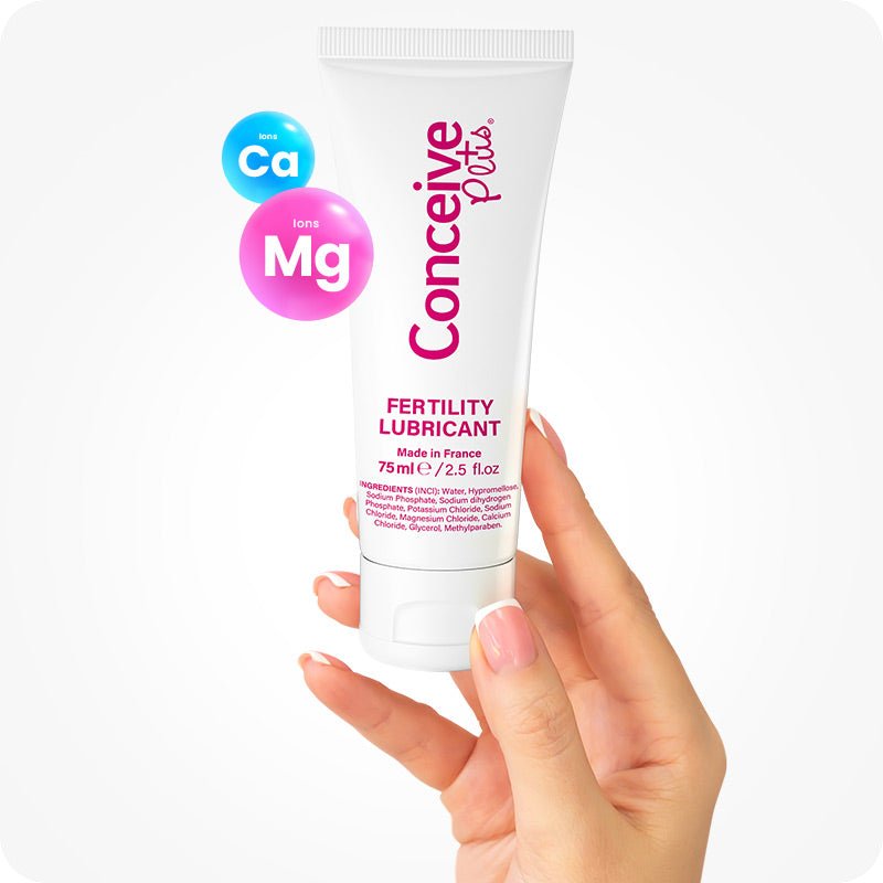 For Conceive Plus Men's Fertility Support + Fertility Lubricant (FR), image of a 75ml fertility lubricant tube held in a female hand, with ingredient ions Ca (Calcium) and Mg (Magnesium) highlighted in floating icons, emphasizing product’s sperm-safe, mineral-rich formula designed to support natural conception.